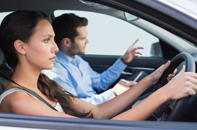 Young woman getting a driving lesson in the car